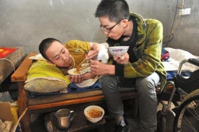 17歲男孩為照顧癱瘓父親 背著爸爸上學